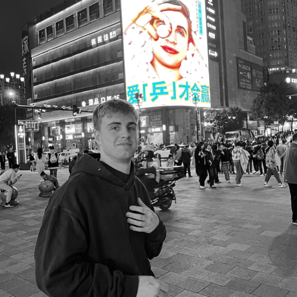 Athlete in a black hood on a lit city street at night with a colour screen in the background